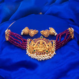 Lakshmi ruby emerald choker set featuring intricate goddess design and pearl accents on a blue background.