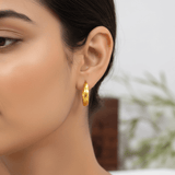 A close-up of a woman's ear wearing a Minimalist Gold-Plated Plain Thin Hoop Earrings For Girls, with her hair pulled back and a softly blurred indoor background.
