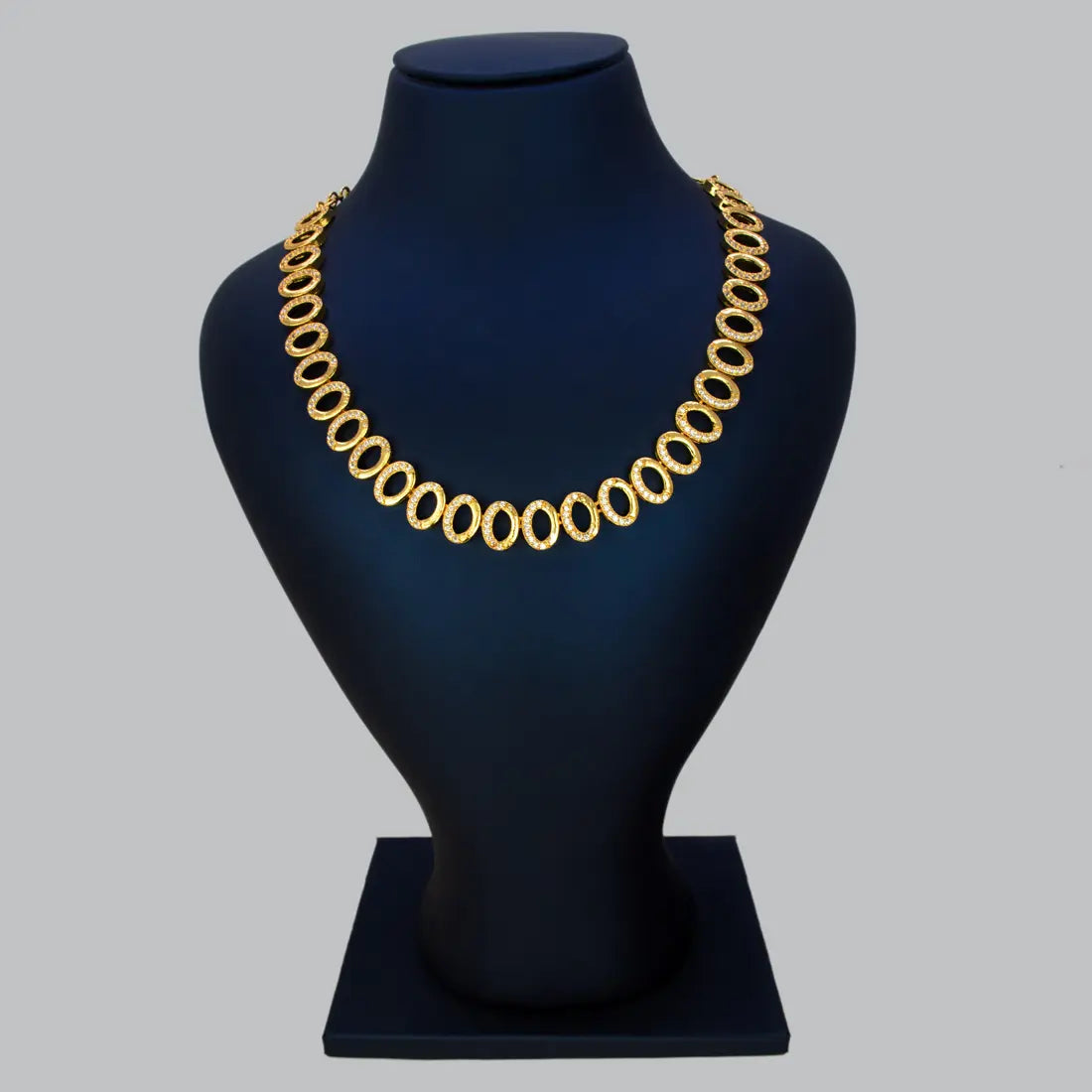 Gold Plated Oval CZ Stone Necklace displayed on a black velvet bust, featuring sparkling cubic zirconia stones.