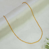 A delicate Popular Gold-Plated Twisted Singapore Chain draped in a U-shape on a soft, off-white textured fabric background.