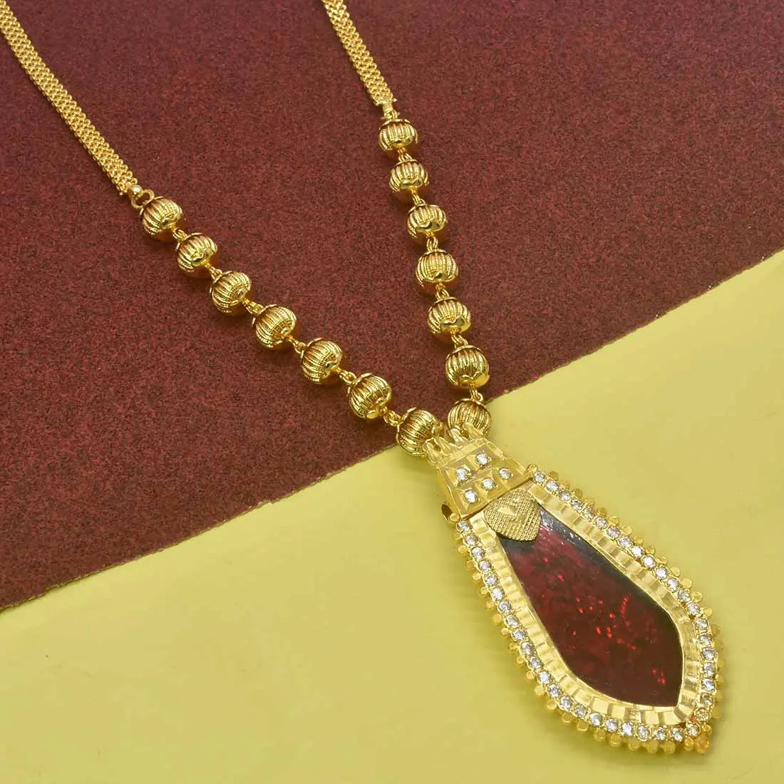 Premium Gold Plated Ball Necklace With Nagapadam Pendant highlighting a striking red gemstone and intricate design.