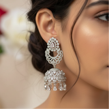 A close-up lifestyle shot of a woman wearing highly detailed silver-toned Rhodium Plated American Diamond Bridal Jhumka Earrings, set against a softly blurred background.