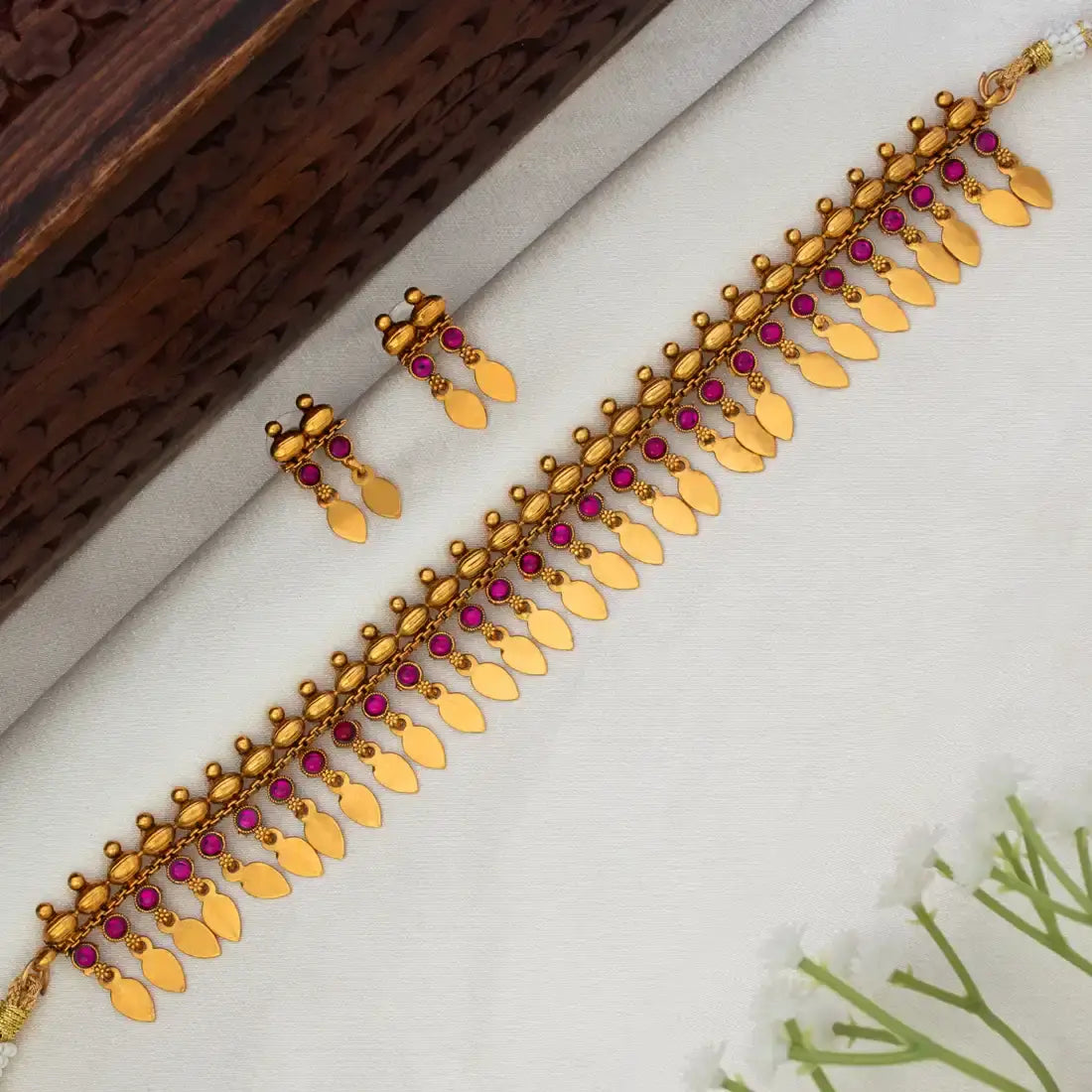 Kemp Stone Antique Gold Plated Elakkathali Necklace Set featuring vibrant kemp stones and gold leaf drops.