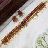 Antique Kemp Elakkathali Choker Necklace Set with magenta square stones, and white pearl-like accents, arranged on a white fabric surface.