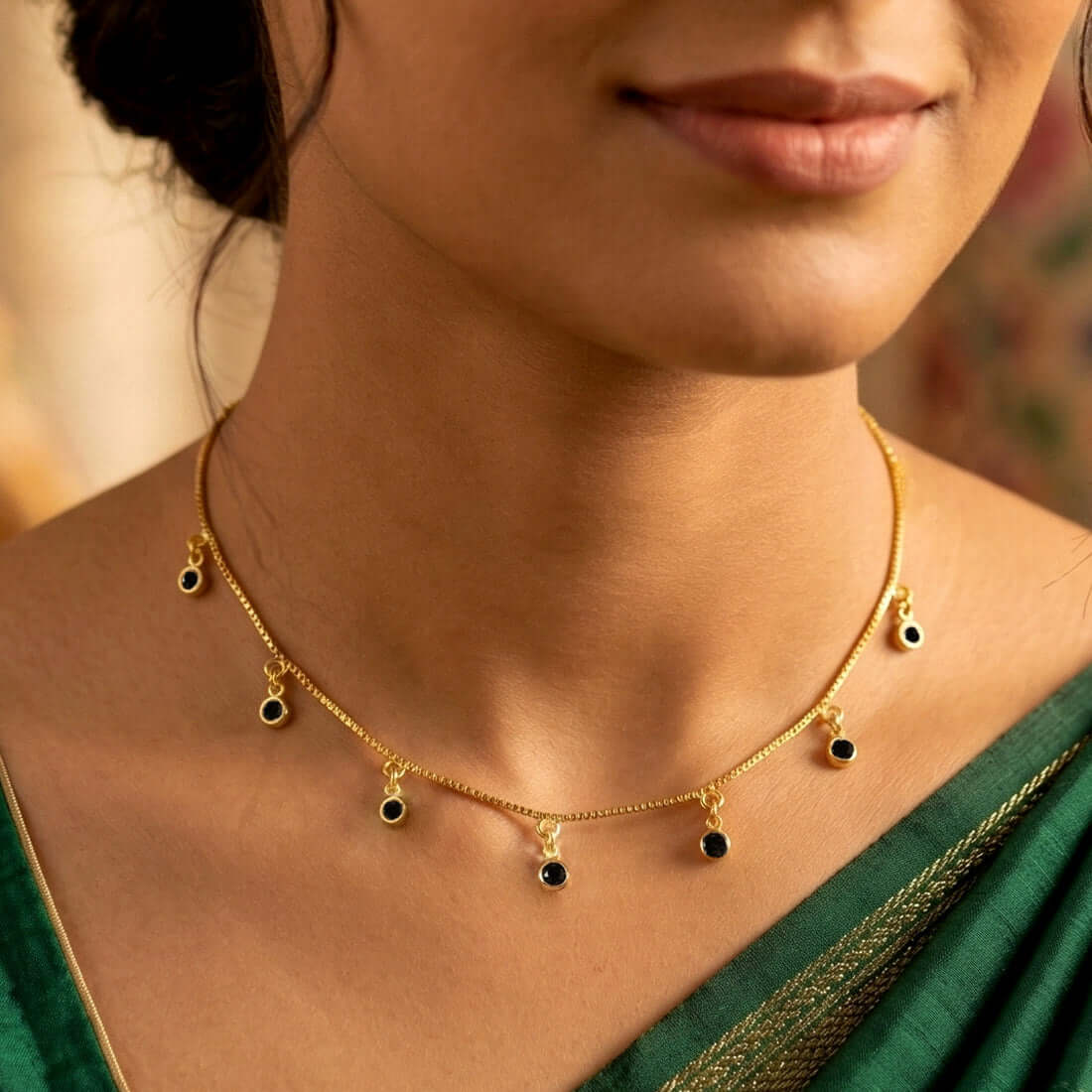 Gold-plated necklace with small black stone pendants