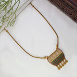 A Victorian Style Antique Stone Mesh Pendant Necklace with a decorative pendant featuring red and green stone accents, displayed on a white textured surface with a small green plant and dark woven prop visible at the edges.