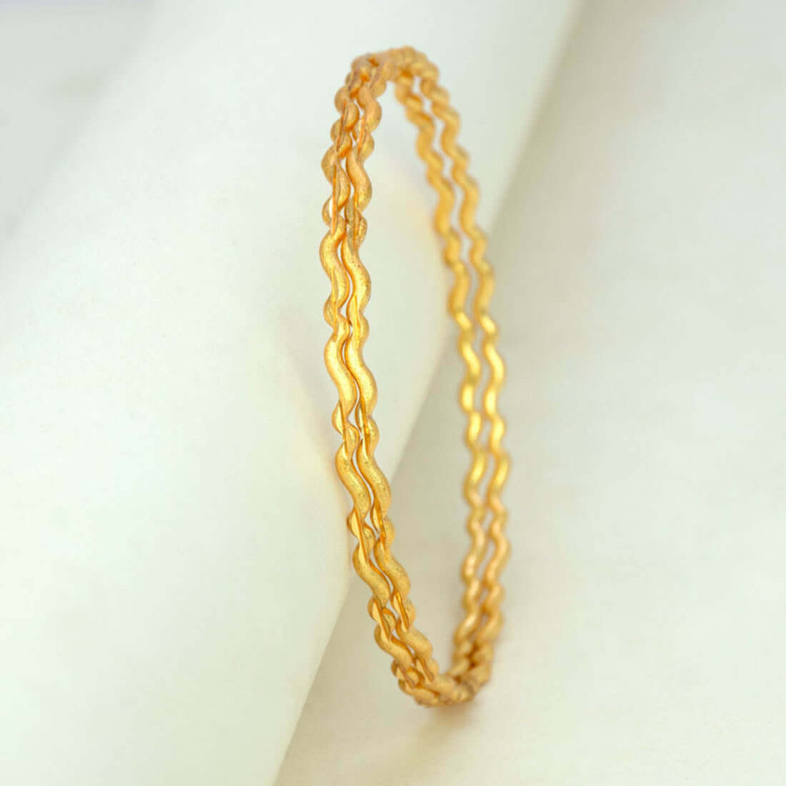 Delicate Gold Plated Wave Pattern Bangles featuring an elegant wave design, perfect for any occasion.