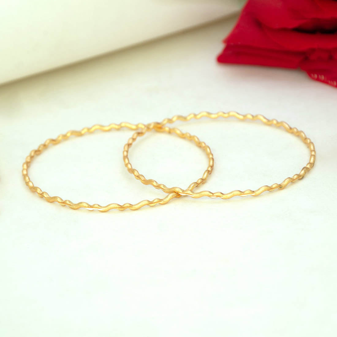 Delicate Gold Plated Wave Pattern Bangles displayed on a neutral background, showcasing their elegant design.