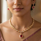 K Supreme gold-plated necklace set with peacock motifs and red cubic zirconia stones, includes matching earrings.