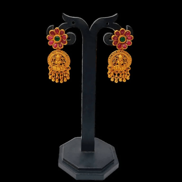 Matte Gold Plated Ruby Emerald Floral Lakshmi Drop Earrings showcased on a display stand, perfect for ethnic occasions.