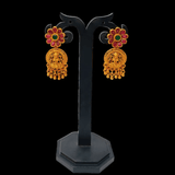 Matte Gold Plated Ruby Emerald Floral Lakshmi Drop Earrings showcased on a display stand, perfect for ethnic occasions.