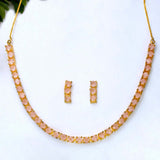Necklace and earrings set with pink stones on a white background